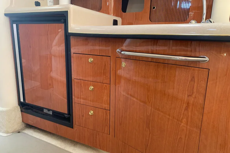 Slide: The Image of 2001 Sea Ray 340 Sundancer interior with wood cabinetry and compact fridge. - 18