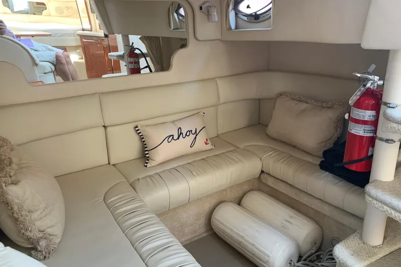 Slide: The Image of Interior of 2001 Sea Ray 340 Sundancer with beige seating, pillows, and fire extinguisher. - 22