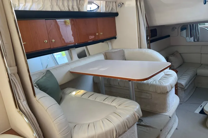 Slide: The Image of Interior of 2001 Sea Ray 340 Sundancer with plush seating and wooden cabinetry. - 23