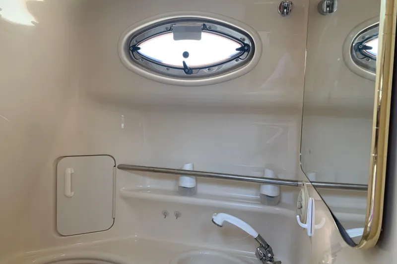Slide: The Image of 2001 Sea Ray 340 Sundancer bathroom with oval window, mirror, and sink. - 27