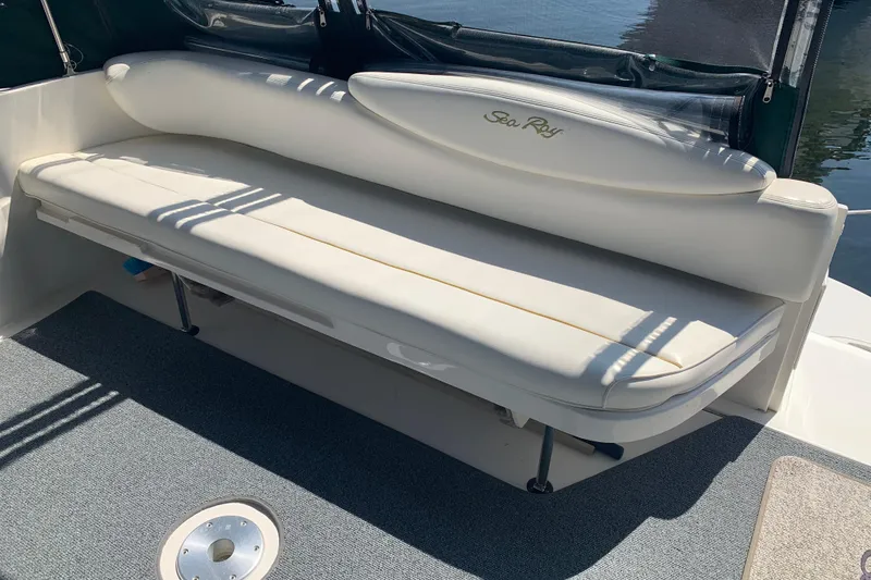 Slide: The Image of White cushioned seating on a 2001 Sea Ray 340 Sundancer boat, with carpeted flooring. - 6