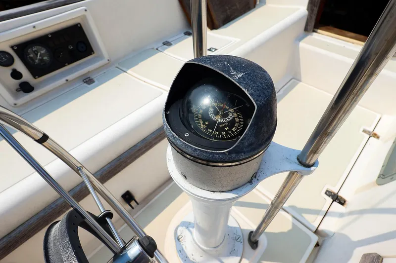 Slide: The Image of Compass on 1985 Island Packed 31 yacht, featuring navigation instruments and steering wheel. - 12
