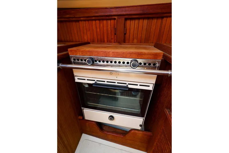 Slide: The Image of Vintage yacht oven in 1985 Island Packed 31, featuring wooden cabinetry and stainless steel accents. - 19