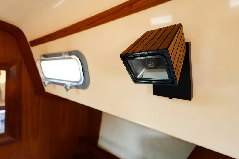 Slide: The Image of Interior of 1985 Island Packed 31 yacht with wooden light fixture and porthole. - 22