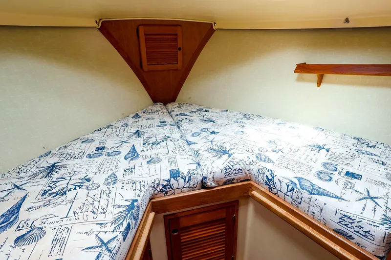 Slide: The Image of Cozy cabin interior of 1985 Island Packed 31 yacht with nautical-themed bedding. - 24
