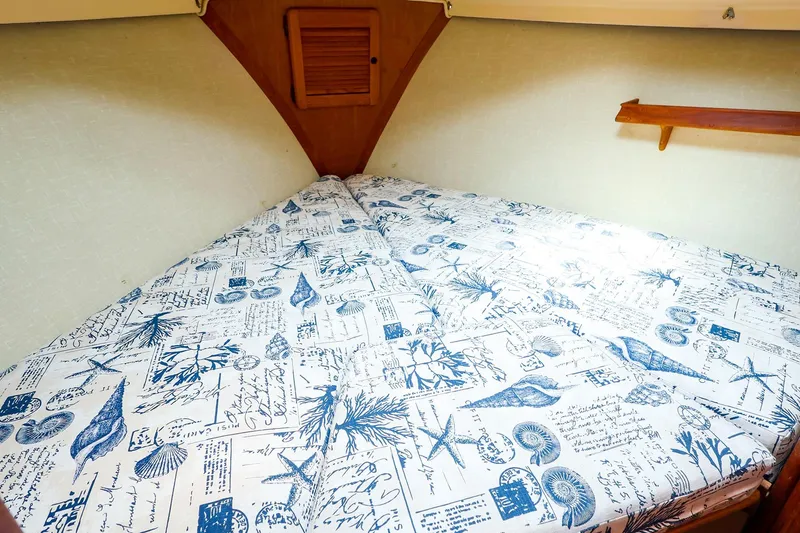 Slide: The Image of Cozy cabin bed in 1985 Island Packed 31 yacht with nautical-themed bedding. - 25