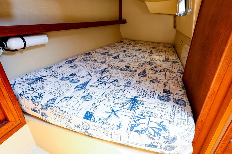 Slide: The Image of Cozy cabin bed in 1985 Island Packed 31 yacht with nautical-themed bedding. - 26
