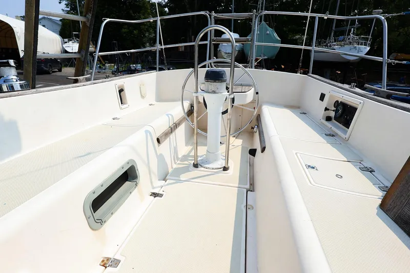 Slide: The Image of 1985 Island Packed Yachts Island Packed 31 sailboat cockpit with steering wheel and seating. - 7