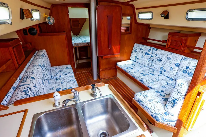 Slide: The Image of Interior of 1985 Island Packed 31 yacht with nautical-themed upholstery and wooden finishes. - 14
