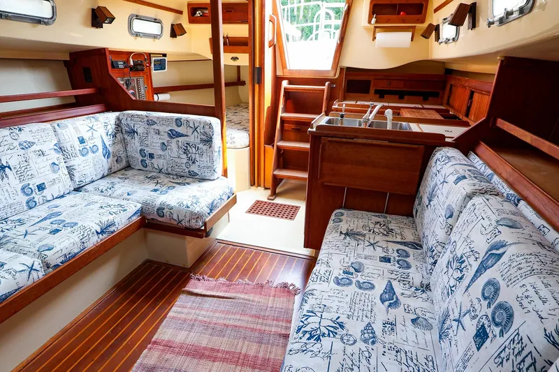 Slide: The Image of Interior of 1985 Island Packed 31 yacht with nautical-themed upholstery and wooden finishes. - 15