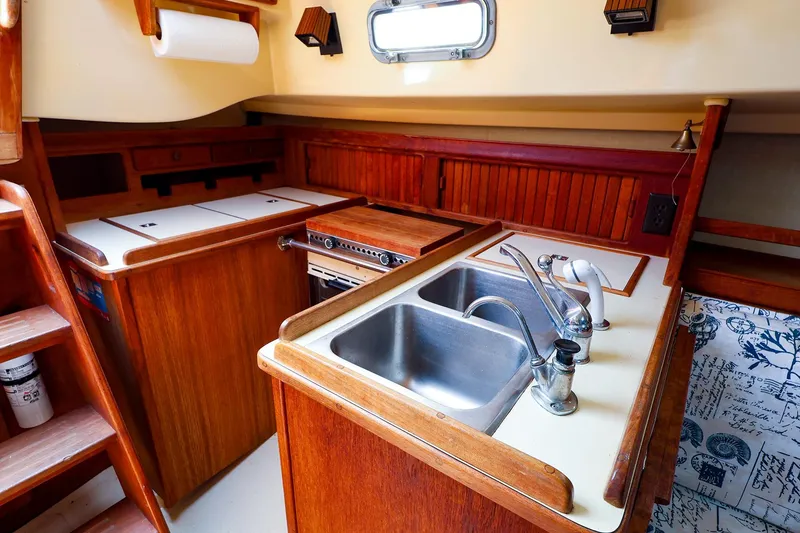 Slide: The Image of 1985 Island Packed 31 yacht kitchen with wooden cabinetry and dual sinks. - 18