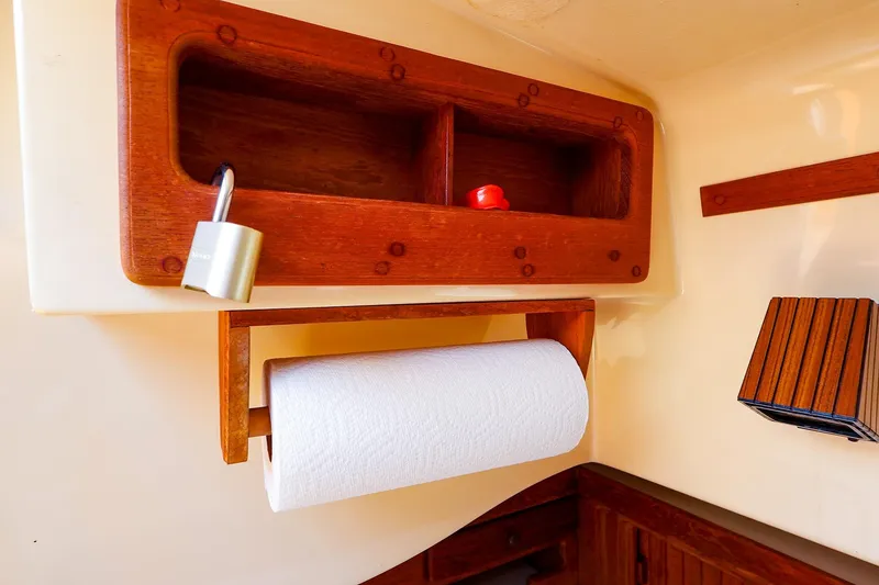 Slide: The Image of Interior of 1985 Island Packed 31 yacht with wooden shelves and paper towel holder. - 20