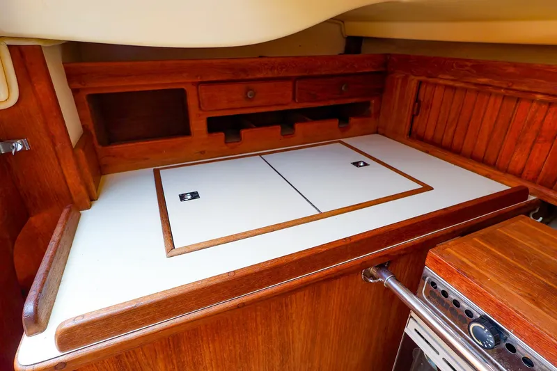 Slide: The Image of 1985 Island Packed 31 yacht interior with wooden cabinetry and white countertop. - 21