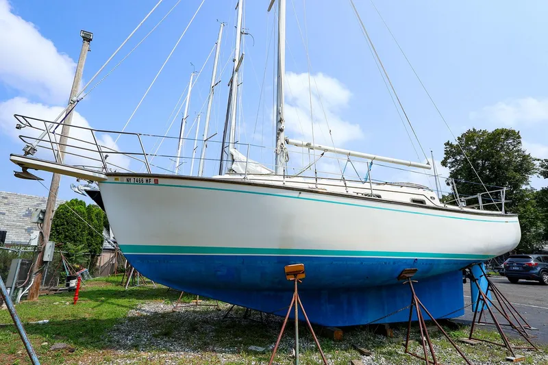Slide: The Image of 1985 Island Packed 31 yacht on stands, ready for maintenance under a clear blue sky. - 3