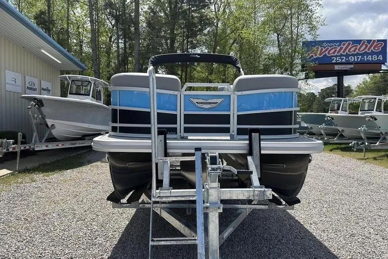 Slide: The Image of 2025 Bennington 22M pontoon boat on trailer, displayed outdoors at dealership. - 3