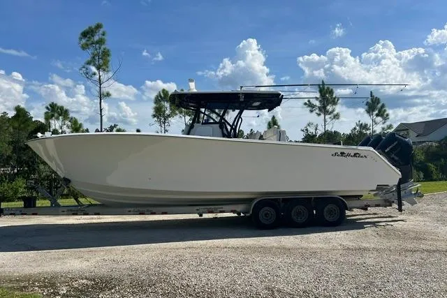Slide: The Image of 2022 SeaHunter 33 Tournament boat on trailer, parked outdoors under a clear blue sky. - 10