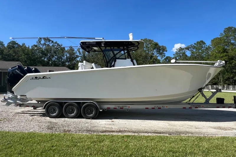 Slide: The Image of 2022 SeaHunter 33 Tournament boat on trailer, parked outdoors under clear blue sky. - 11