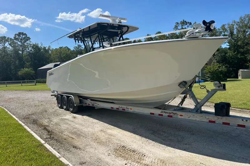 Slide: The Image of 2022 SeaHunter 33 Tournament boat on trailer, parked outdoors under clear blue sky. - 5