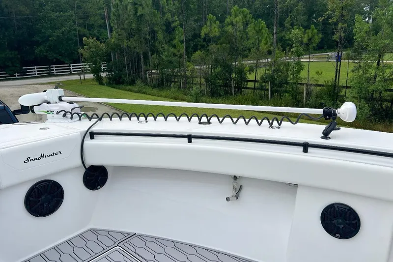 Slide: The Image of 2022 SeaHunter 33 Tournament boat with mounted equipment, surrounded by lush greenery. - 8