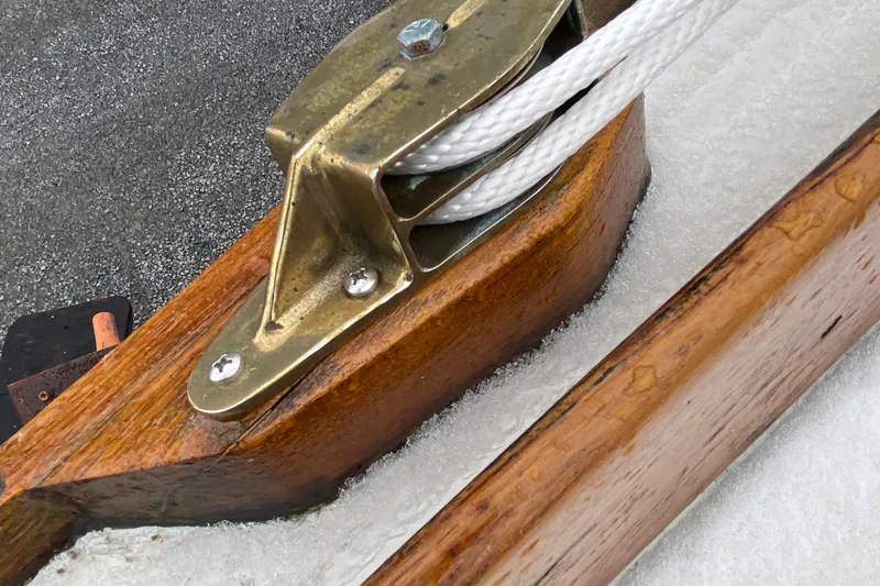Slide: The Image of Close-up of a 1972 Bristol 40 sailboat pulley system with wooden and metal components. - 17