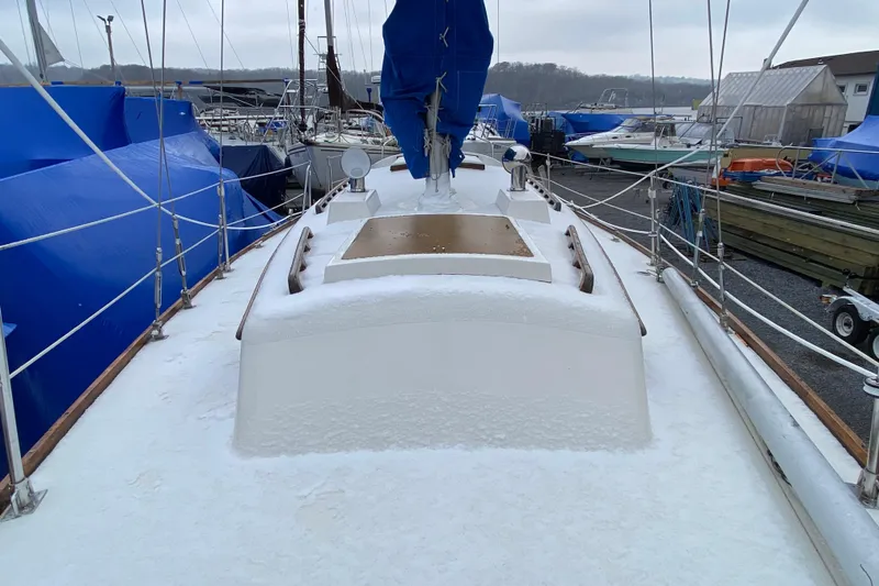Slide: The Image of 1972 Bristol 40 sailboat covered in snow at a marina. - 24