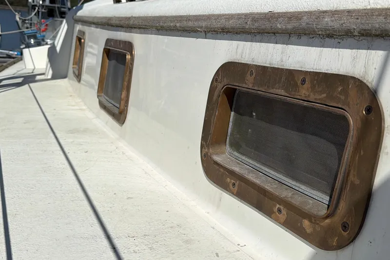 Slide: The Image of Close-up of 1972 Bristol 40 boat portholes with brass frames and white deck. - 29