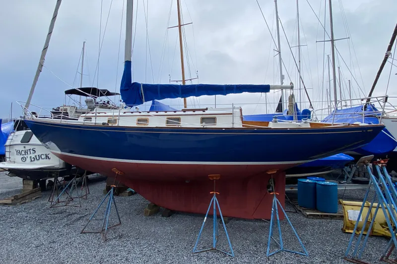 Slide: The Image of 1972 Bristol 40 sailboat on dry dock, blue hull, white deck, marina setting. - 3