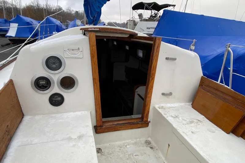 Slide: The Image of 1972 Bristol 40 sailboat cockpit with gauges, wooden trim, and blue tarps in background. - 30