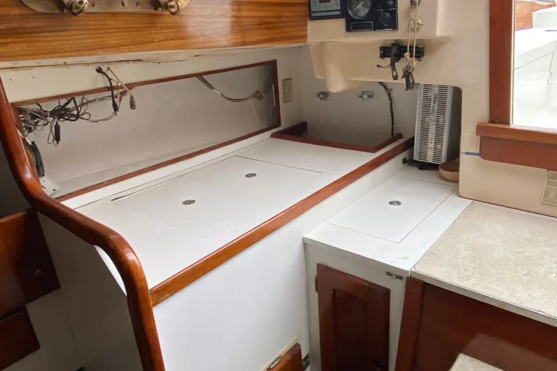 Slide: The Image of 1972 Bristol 40 yacht interior with wooden cabinetry and white countertops. - 35