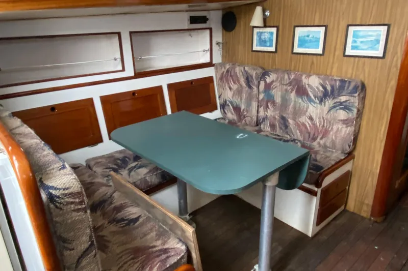 Slide: The Image of 1972 Bristol 40 yacht interior with dining area, cushioned seating, and framed artwork. - 46