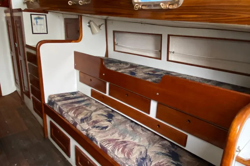 Slide: The Image of Interior of a 1972 Bristol 40 sailboat with wooden cabinetry and patterned cushions. - 49