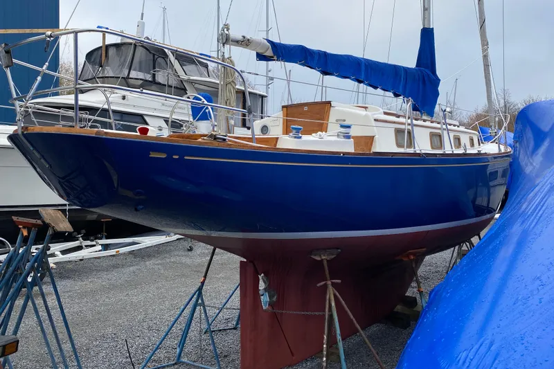 Slide: The Image of 1972 Bristol 40 sailboat in dry dock, blue hull, white deck, marina setting. - 5