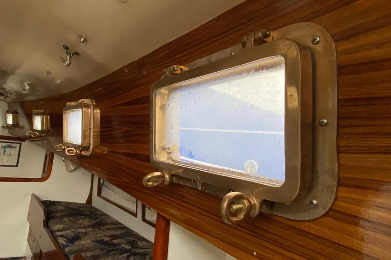 Slide: The Image of Interior of a 1972 Bristol 40 sailboat with wooden paneling and brass portholes. - 50