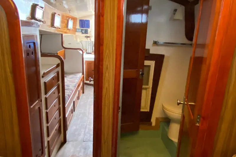 Slide: The Image of Interior of a 1972 Bristol 40 sailboat featuring wooden cabinetry and a compact bathroom. - 57