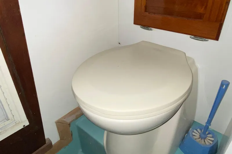 Slide: The Image of 1972 Bristol 40 boat bathroom with closed toilet lid and brush. - 58