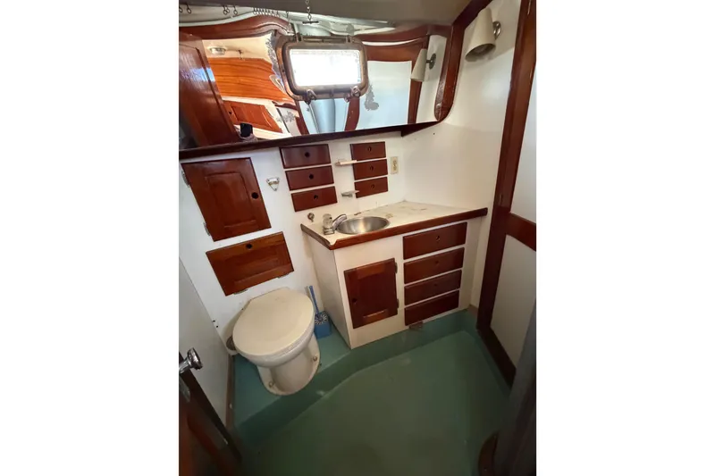 Slide: The Image of 1972 Bristol 40 yacht bathroom with wooden cabinets, sink, and toilet. - 69