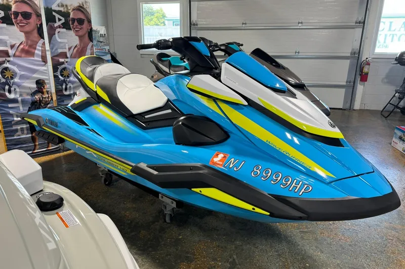 Slide: The Image of 2023 Yamaha WaveRunner FX Cruiser HO in showroom, vibrant blue and yellow design. - 1