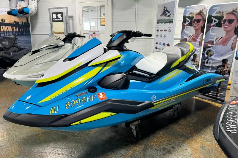Slide: The Image of 2023 Yamaha WaveRunner FX Cruiser HO in showroom, blue and yellow design. - 2