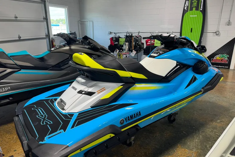 Slide: The Image of 2023 Yamaha WaveRunner FX Cruiser HO in showroom, vibrant blue and yellow design. - 4