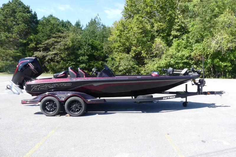 Slide: The Image of 2026 Nitro Z21 XL Pro bass boat on trailer, parked outdoors with trees in background. - 85
