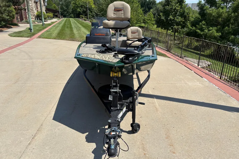 Slide: The Image of 2026 Tracker Bass Tracker Classic Limited boat on a driveway, surrounded by greenery. - 2