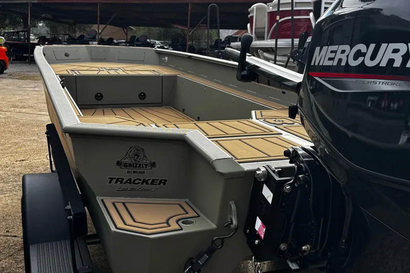Slide: The Image of 2026 Tracker Grizzly 1650 T Prairie Wings Edition boat with Mercury engine, parked outdoors. - 25