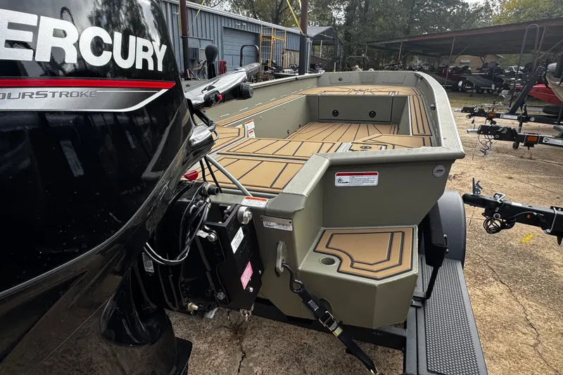 Slide: The Image of 2026 Tracker Grizzly 1650 T Prairie Wings Edition boat with Mercury engine, parked outdoors. - 27