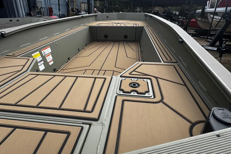 Slide: The Image of 2026 Tracker Grizzly 1650 T Prairie Wings Edition boat interior with tan deck and storage compartments. - 28