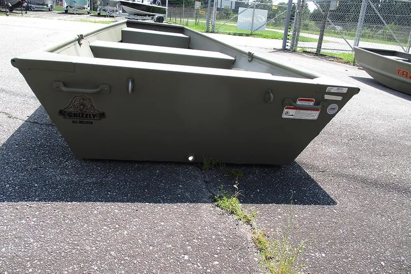 Slide: The Image of 2026 Tracker Grizzly 12 Jon boat on pavement, showcasing its sturdy, all-welded design. - 8