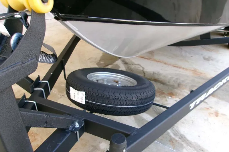 Slide: The Image of 2026 Tracker Targa V-18 WT boat trailer with spare tire on concrete surface. - 13