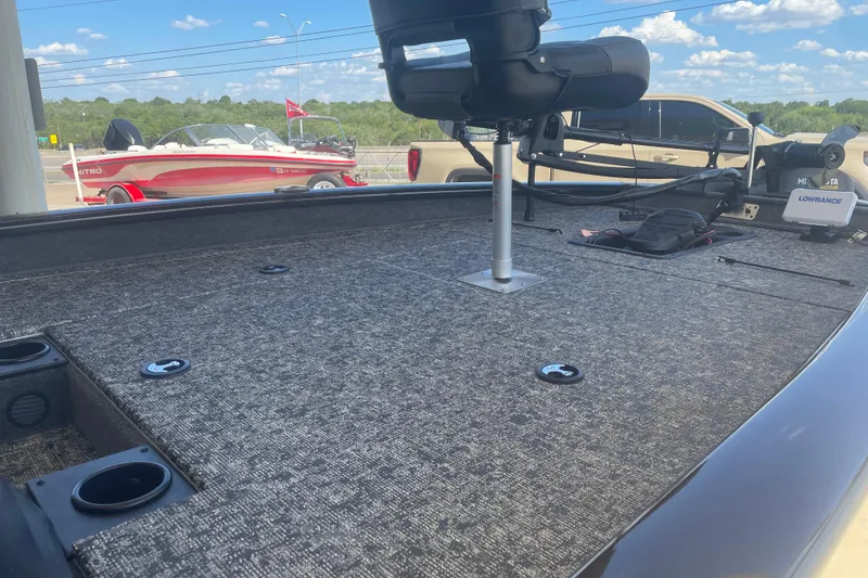 Slide: The Image of 2026 Tracker Pro Team 190 boat interior with fishing seat and equipment, under a clear blue sky. - 7