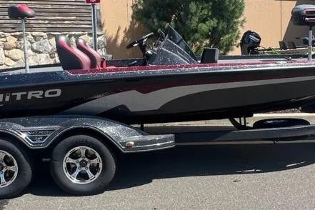 The Image of 2026 Nitro Z21 XL Pro boat on trailer, sleek design, black and red accents. - 0