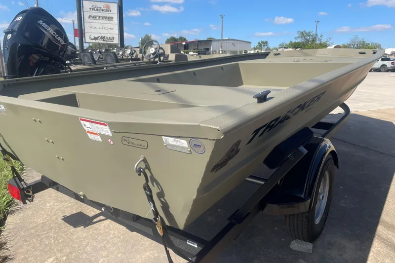 Slide: The Image of 2026 Tracker Grizzly 1754 Utility boat on trailer, displayed outdoors under clear sky. - 2