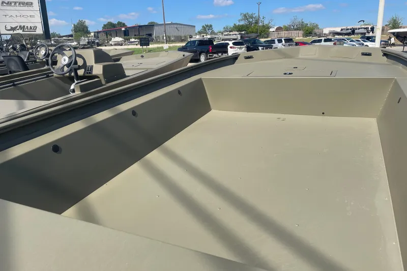 Slide: The Image of 2026 Tracker Grizzly 1754 Utility boat, olive green, parked outdoors under blue sky. - 6